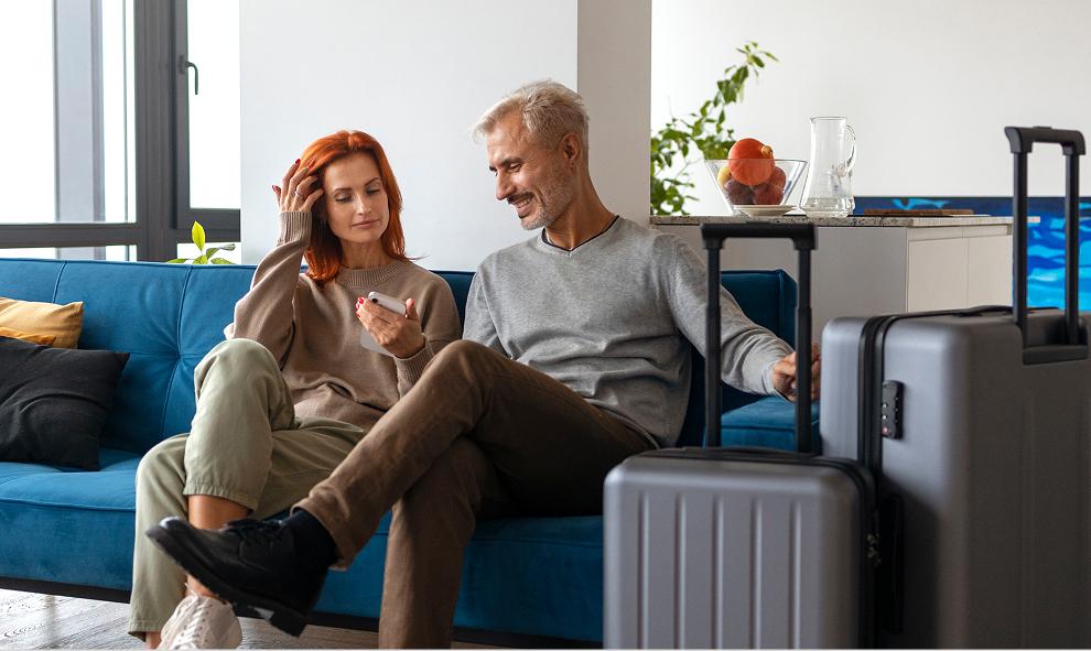 Pareja sentada junto a valijas antes de viajar